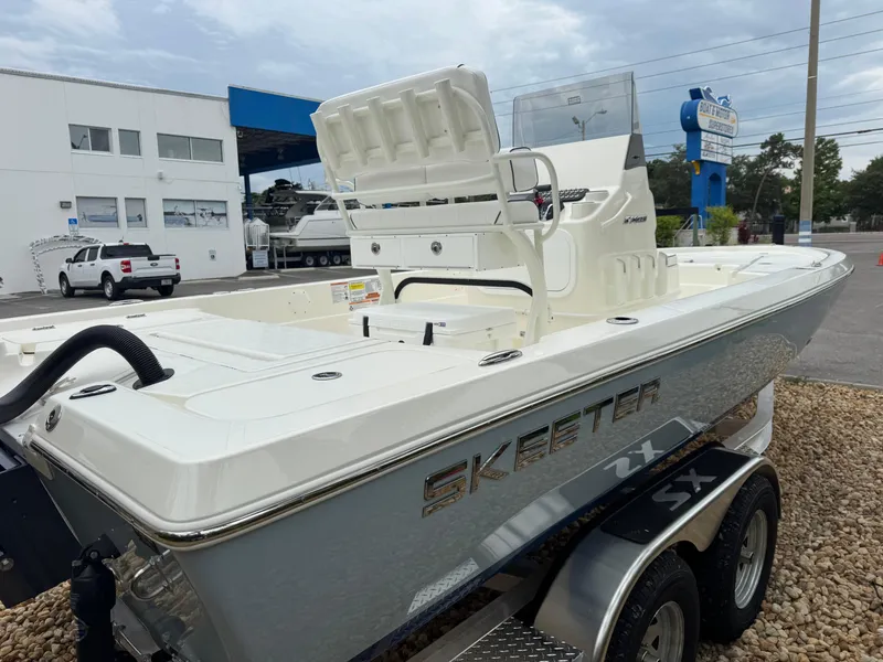 Slide: The Image of 2025 Skeeter SX 221 boat on trailer, parked outdoors near dealership. - 12