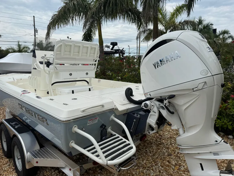 Slide: The Image of 2025 Skeeter SX 221 boat with Yamaha engine, parked on a trailer, surrounded by palm trees. - 15