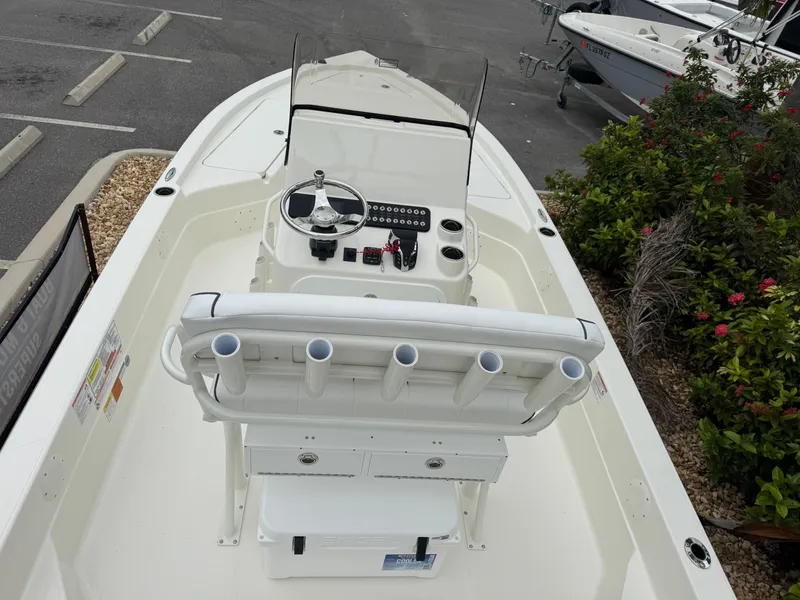Slide: The Image of 2025 Skeeter SX 221 boat interior with console and rod holders, parked in a marina. - 19