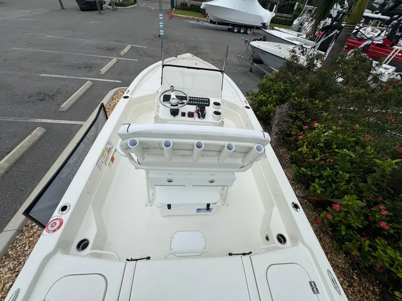 Slide: The Image of 2025 Skeeter SX 221 boat, top view, parked in a marina with lush greenery nearby. - 20
