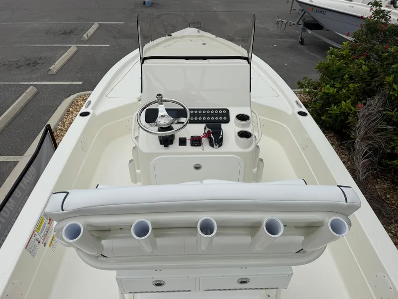 Slide: The Image of 2025 Skeeter SX 221 boat interior with steering console and rod holders in a parking lot. - 22