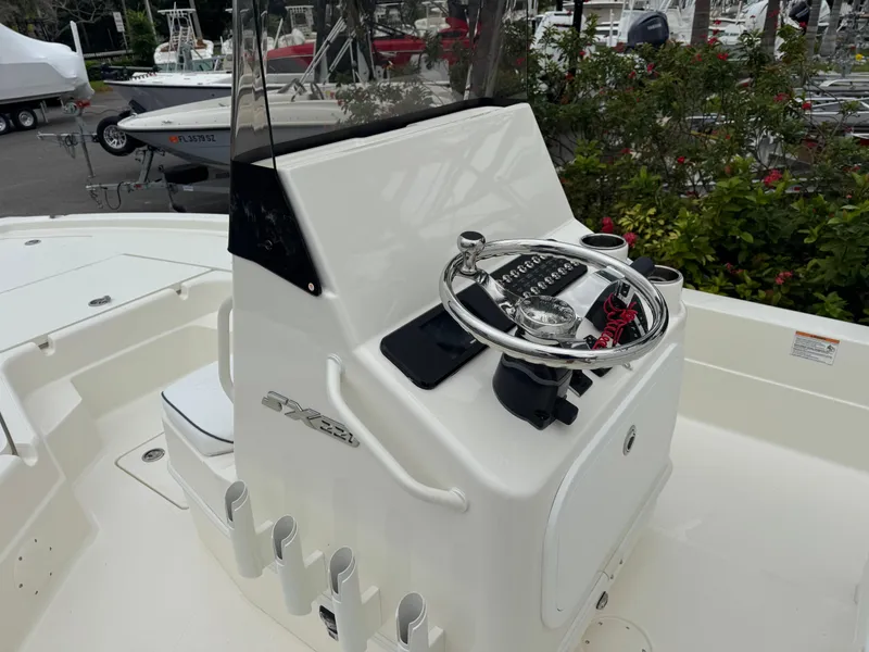 Slide: The Image of 2025 Skeeter SX 221 boat console with steering wheel and controls, docked outdoors. - 24