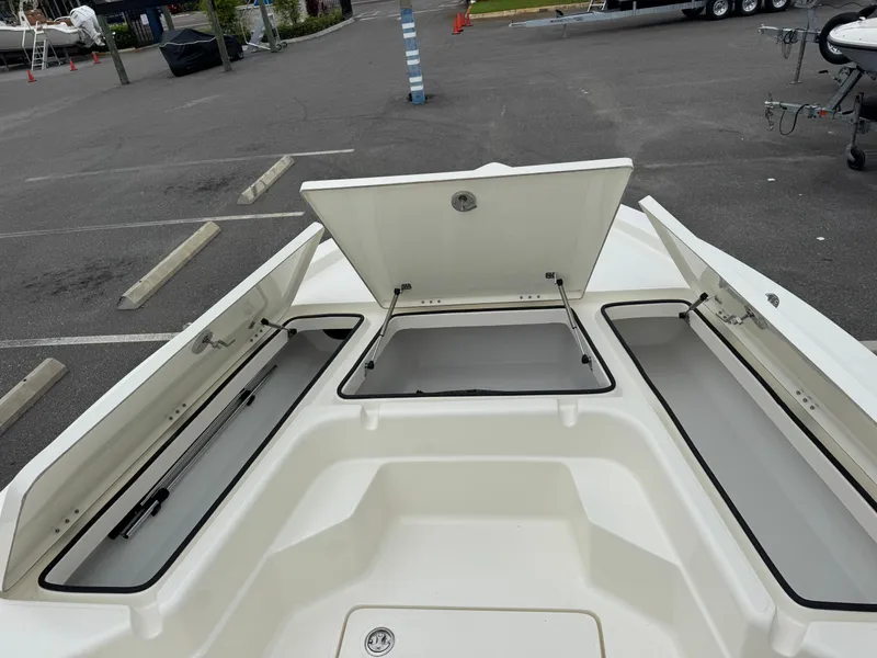 Slide: The Image of 2025 Skeeter SX 221 boat with open storage compartments in a parking lot. - 29