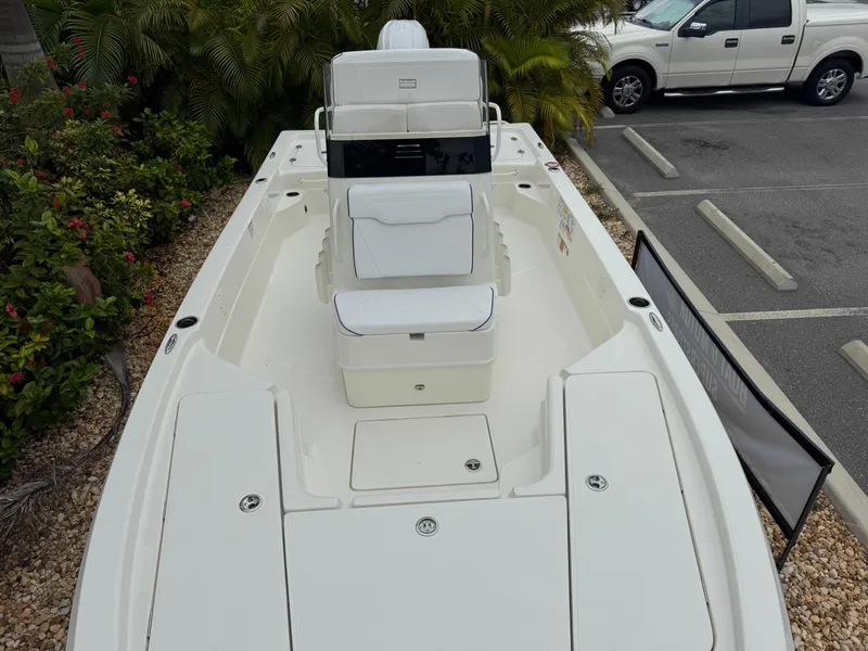 Slide: The Image of 2025 Skeeter SX 221 boat, white deck, parked near greenery and a vehicle. - 31