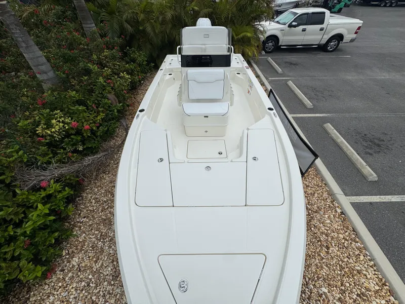 Slide: The Image of 2025 Skeeter SX 221 boat in parking lot, surrounded by greenery and vehicles. - 32