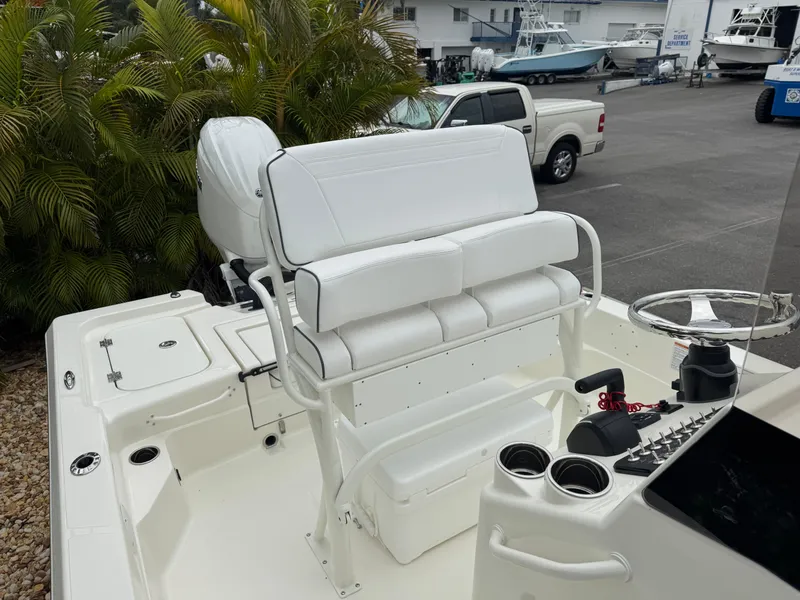 Slide: The Image of 2025 Skeeter SX 221 boat with white seating and console, parked near other boats. - 36