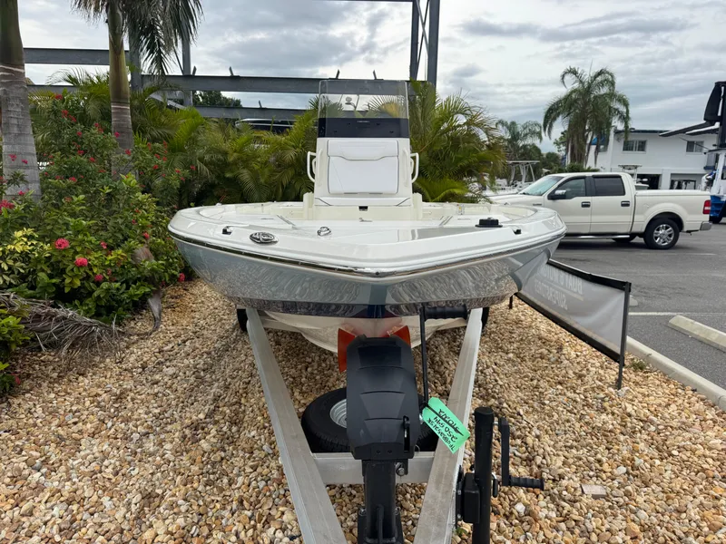 Slide: The Image of 2025 Skeeter SX 221 boat on trailer, surrounded by tropical plants and parked vehicles. - 4