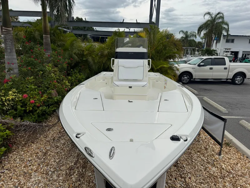Slide: The Image of 2025 Skeeter SX 221 boat displayed outdoors with lush greenery and parked vehicles. - 5