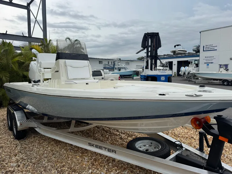 Slide: The Image of 2025 Skeeter SX 221 boat on trailer at marina, cloudy sky background. - 6