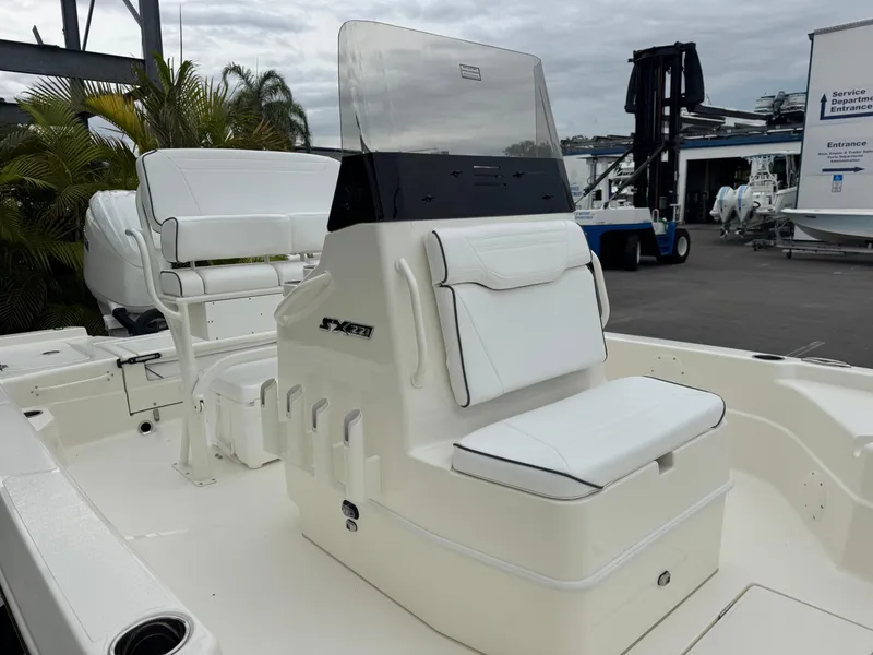 Slide: The Image of 2025 Skeeter SX 221 boat interior with white seating and console, dockside view. - 9