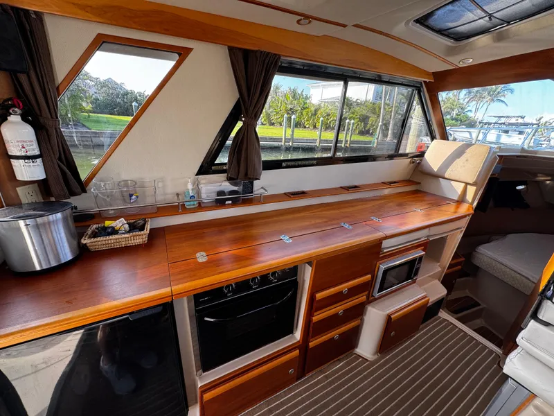 Slide: The Image of Interior of 2014 Cutwater 30 Sedan LE with wooden cabinetry and modern appliances. - 10