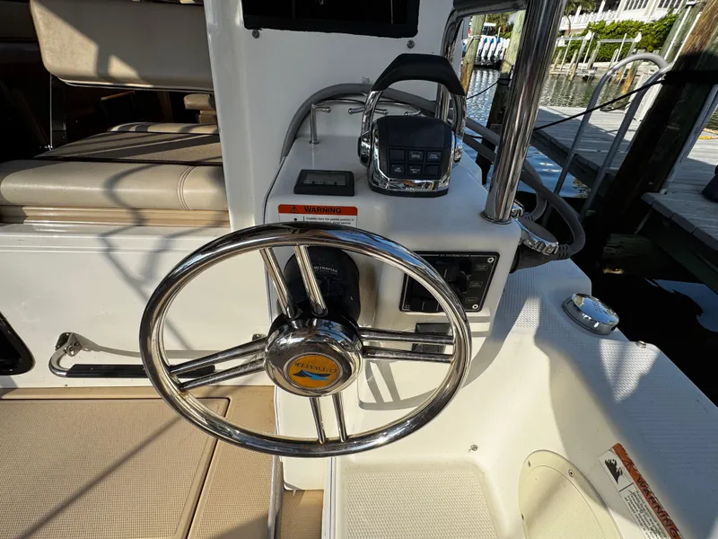 Slide: The Image of Steering wheel of a 2014 Cutwater 30 Sedan LE boat, docked with visible controls. - 6