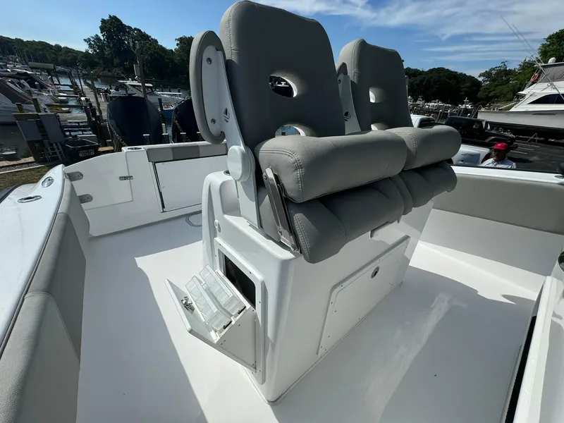 Slide: The Image of 2025 Cape Horn 27 XS boat with cushioned seating, docked at a marina. - 22