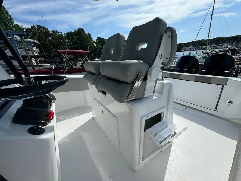 Slide: The Image of 2025 Cape Horn 27 XS boat interior with dual cushioned seats and storage compartment. - 23