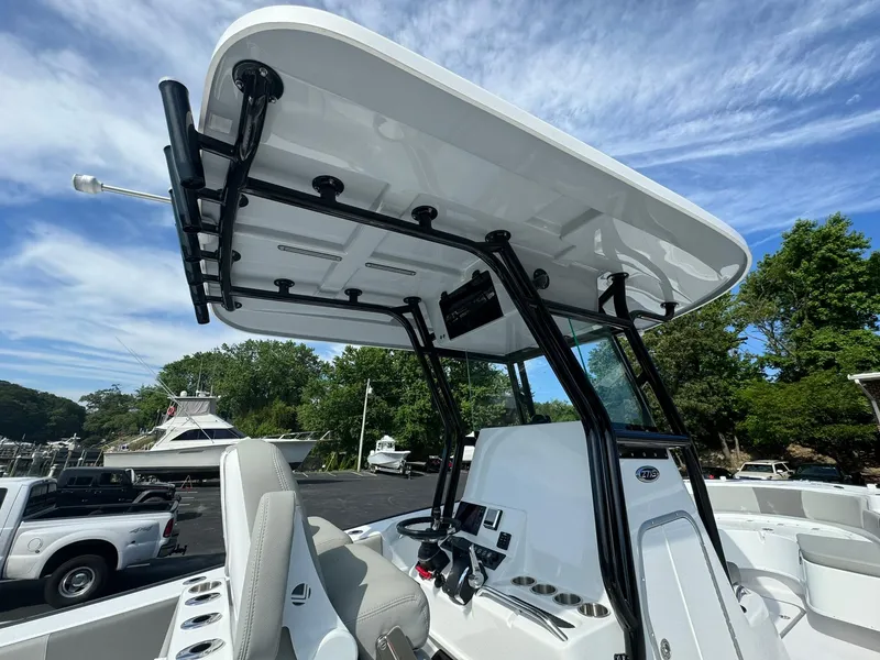 Slide: The Image of 2025 Cape Horn 27 XS boat with T-top, parked outdoors under a blue sky. - 16