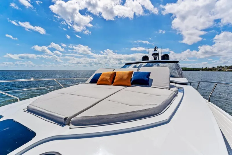 Slide: The Image of 2024 Uniesse Exuma HTC5p yacht with sunbathing deck, cushions, and ocean view. - 11