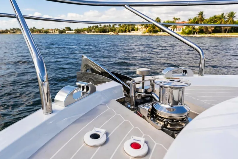 Slide: The Image of 2024 Uniesse Exuma HTC5p yacht deck with chrome fittings, ocean view, and distant shoreline. - 12