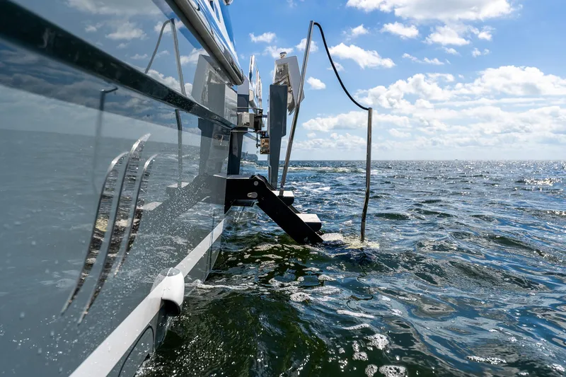 Slide: The Image of 2024 Uniesse Exuma HTC5p yacht on open water under blue sky. - 14