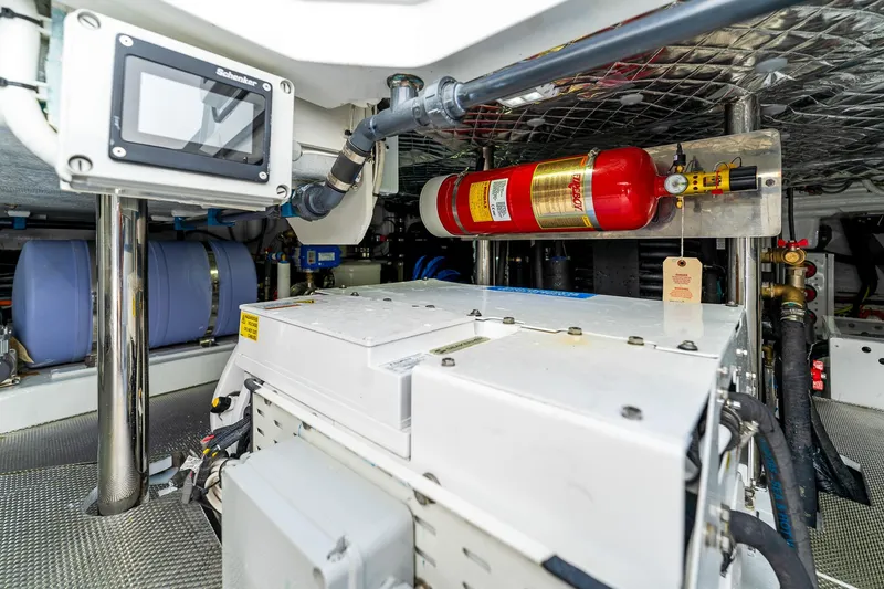 Slide: The Image of Engine room of 2024 Uniesse Exuma HTC5p yacht with fire extinguisher and control panel. - 36