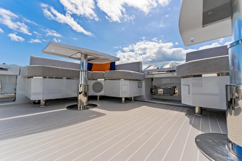 Slide: The Image of 2024 Uniesse Exuma HTC5p yacht deck with modern seating and table under blue sky. - 5