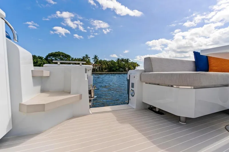 Slide: The Image of 2024 Uniesse Exuma HTC5p yacht deck with seating, overlooking serene water and blue sky. - 6