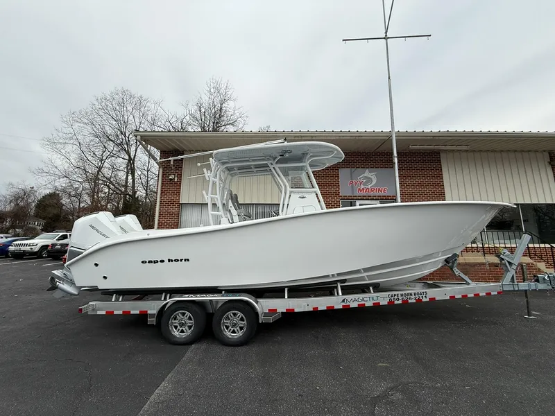 Slide: The Image of 2025 Cape Horn 28 XS boat on trailer, parked outside a building. - 1