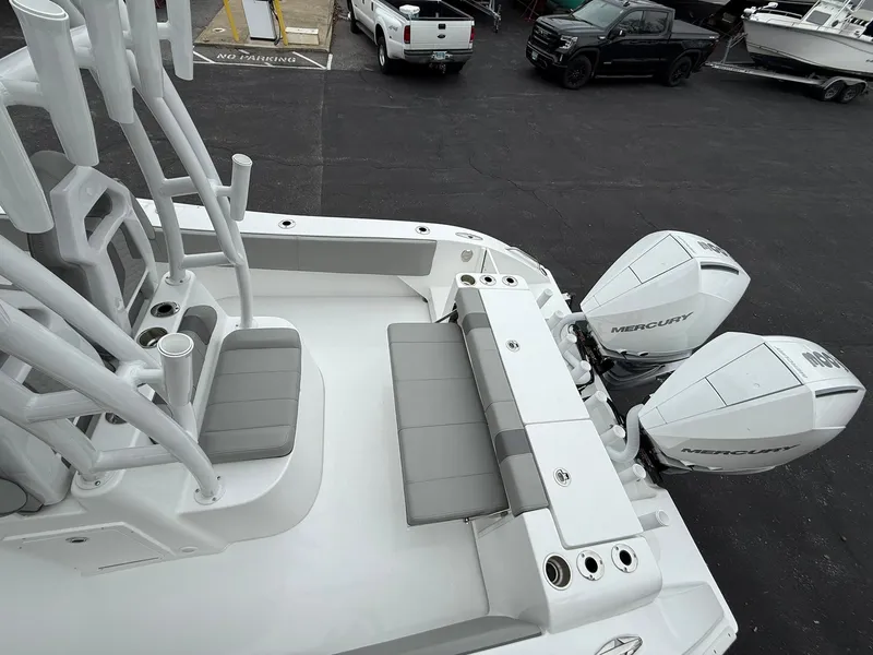 Slide: The Image of 2025 Cape Horn 28 XS boat with dual Mercury engines, docked in a parking area. - 20