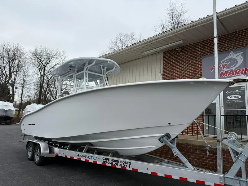 The Image of 2025 Cape Horn 28 XS boat on trailer outside a marine dealership. - 0