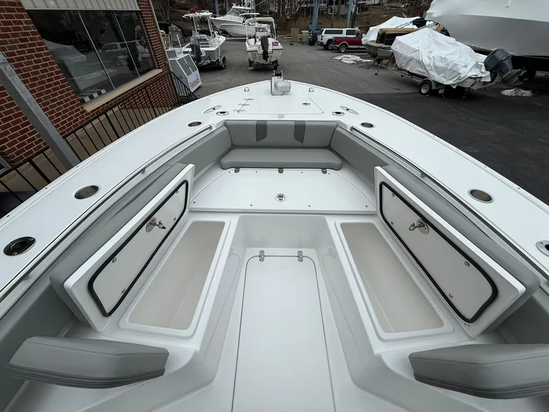 Slide: The Image of 2025 Cape Horn 28 XS boat with open storage compartments, docked outdoors. - 2