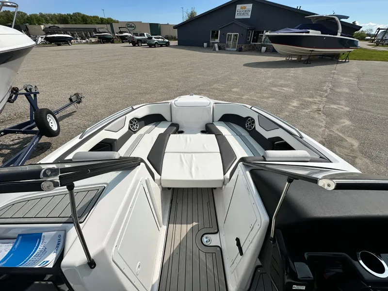 Slide: The Image of 2022 Yamaha Boats 212SD interior, featuring spacious seating and modern design in a boatyard setting. - 10