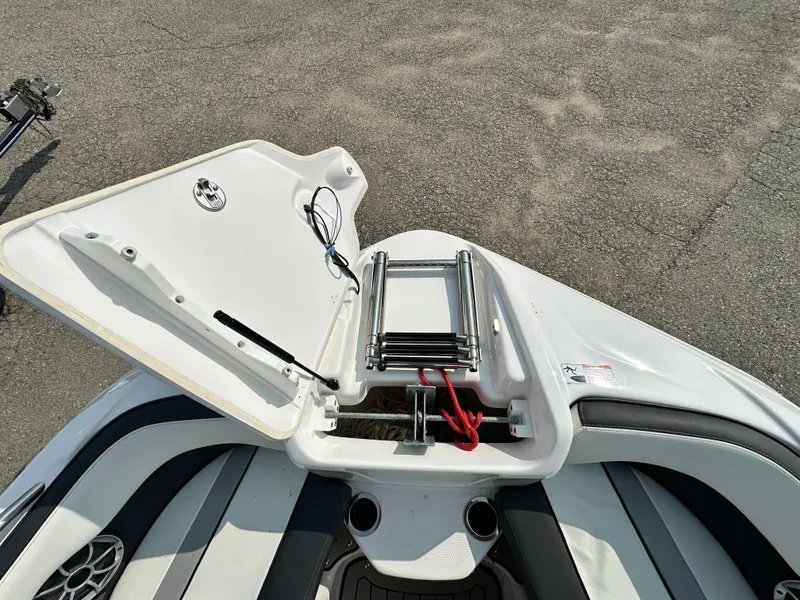 Slide: The Image of 2022 Yamaha Boats 212SD bow with open storage compartment and ladder. - 12