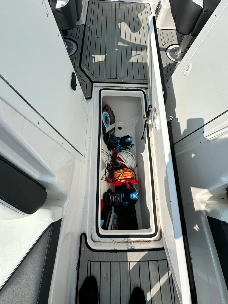 Slide: The Image of 2022 Yamaha Boats 212SD interior storage with wakeboard equipment. - 13