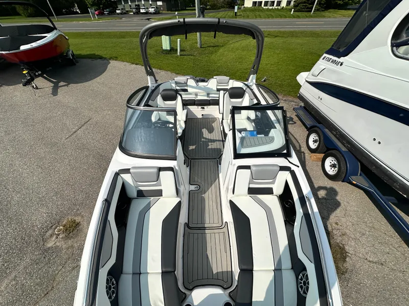 Slide: The Image of 2022 Yamaha Boats 212SD, sleek interior design, parked on a trailer. - 14