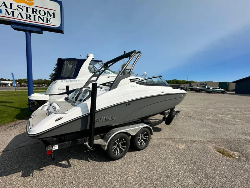 Slide: The Image of 2022 Yamaha Boats 212SD on trailer at dealership, sunny day. - 19
