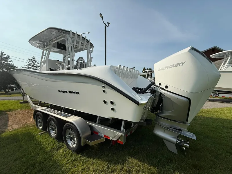 Slide: The Image of 2025 Cape Horn 32 XS boat on trailer with Mercury engine, parked on grass. - 6
