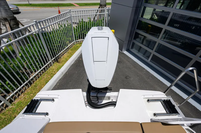 Slide: The Image of 2026 Monterey Elite 27 OB boat engine view, parked near a metal fence. - 25