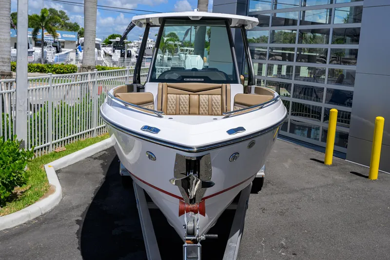 Slide: The Image of 2026 Monterey Elite 27 OB boat on trailer, parked outdoors near a modern building. - 3