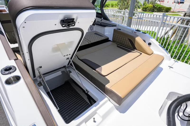 Slide: The Image of 2026 Monterey Elite 27 OB boat with open storage compartment and tan seating. - 9