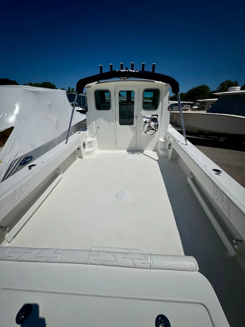 Slide: The Image of 2025 Parker 2820 XLD Sport Cabin boat with spacious deck and cabin under clear blue sky. - 4