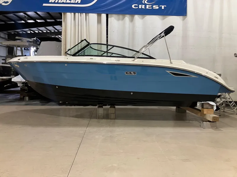 Slide: The Image of 2025 Sea Ray SDX 250 boat in showroom, blue and white exterior. - 1