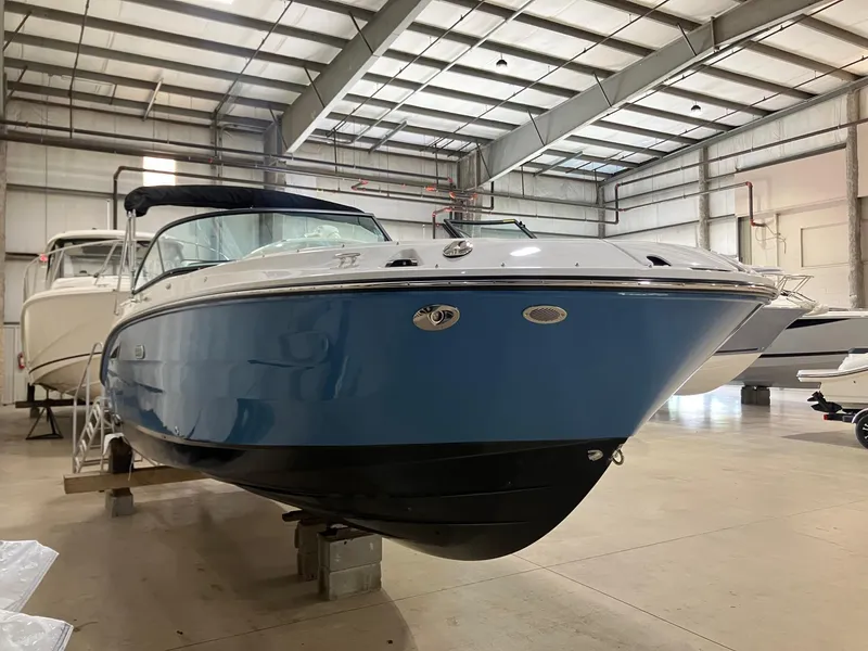 Slide: The Image of 2025 Sea Ray SDX 250 boat in a spacious indoor showroom. - 2