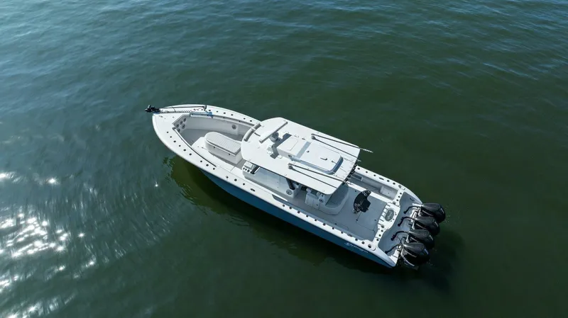 Slide: The Image of 2021 Yellowfin 39 boat on calm water, aerial view, featuring triple outboard engines. - 38