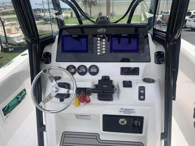 Slide: The Image of 2023 Sea Fox 268 Commander boat dashboard with dual screens and steering wheel. - 16