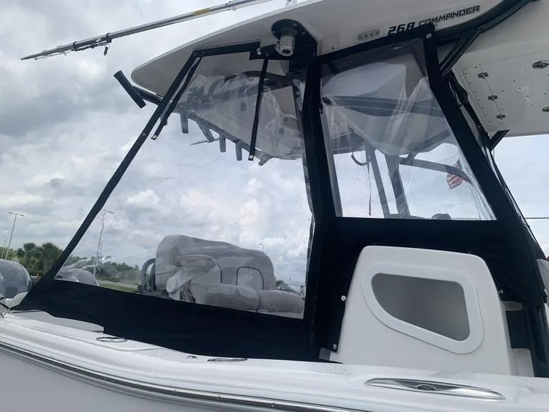 Slide: The Image of 2023 Sea Fox 268 Commander boat with clear enclosure and seating, under cloudy sky. - 35