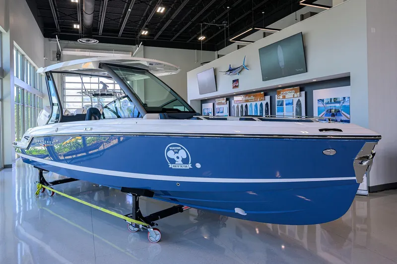 The Image of 2026 Monterey Elite 27 OB boat displayed indoors, blue hull, modern design. - 1
