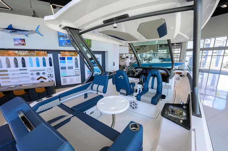 Slide: The Image of 2026 Monterey Elite 27 OB boat interior with blue seating and modern dashboard in showroom. - 10