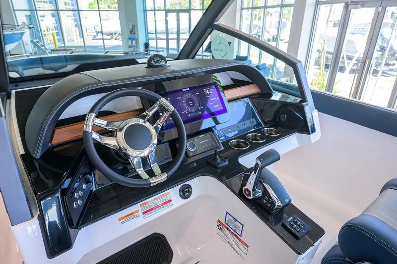 Slide: The Image of 2026 Monterey Elite 27 OB boat dashboard with modern steering and digital display. - 6