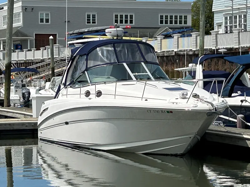 The Image of 2005 Sea Ray 300 Sundancer docked at marina, reflecting on calm water. - 0