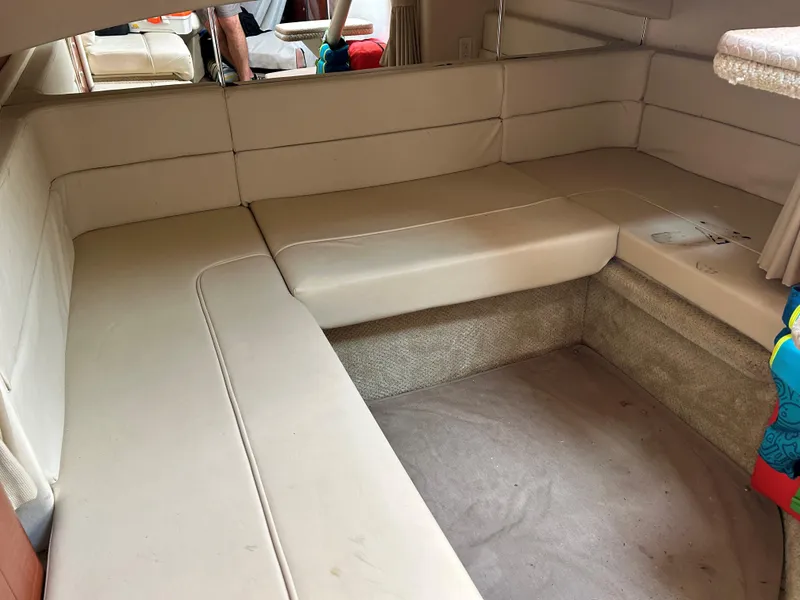 Slide: The Image of 2005 Sea Ray 300 Sundancer interior with beige seating and carpeted flooring. - 18