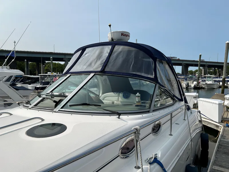 Slide: The Image of 2005 Sea Ray 300 Sundancer docked at marina, featuring sleek design and covered cockpit. - 6